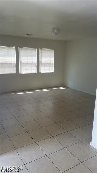 spare room featuring light tile patterned floors and plenty of natural light