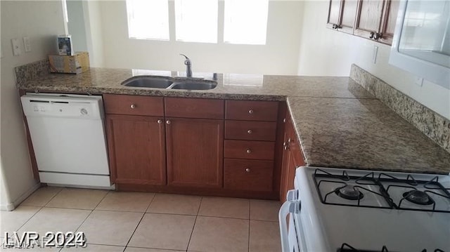 kitchen featuring light tile patterned flooring, sink, and white appliances