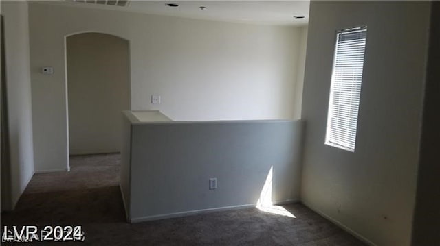 unfurnished room featuring dark colored carpet