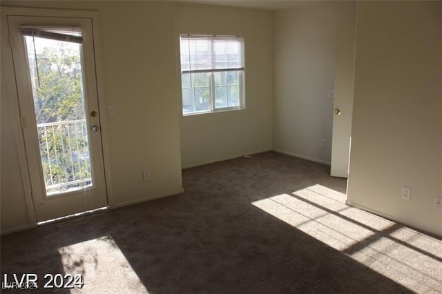 unfurnished room with dark carpet