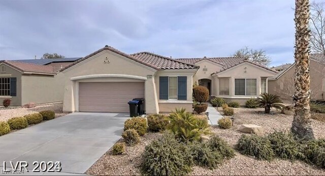 1652 Black Fox Canyon Rd, Henderson, NV 89052 - mediterranean / spanish-style home with stucco siding, concrete driveway, an attached garage, solar panels, and a tile roof