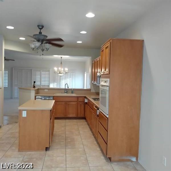 1652 Black Fox Canyon Rd, Henderson, NV 89052 - kitchen with white oven, a sink, a peninsula, recessed lighting, and ceiling fan