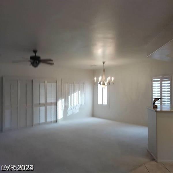 1652 Black Fox Canyon Rd, Henderson, NV 89052 - empty room with a chandelier, ceiling fan, light tile patterned floors, and light carpet