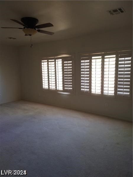 empty room featuring carpet floors and ceiling fan