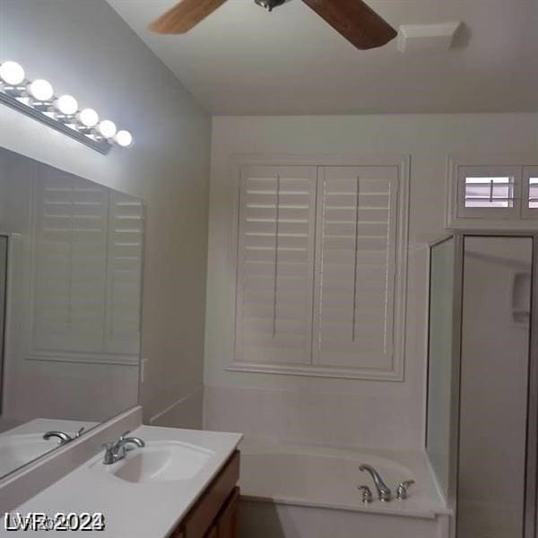 bathroom with vanity, a tub to relax in, and ceiling fan