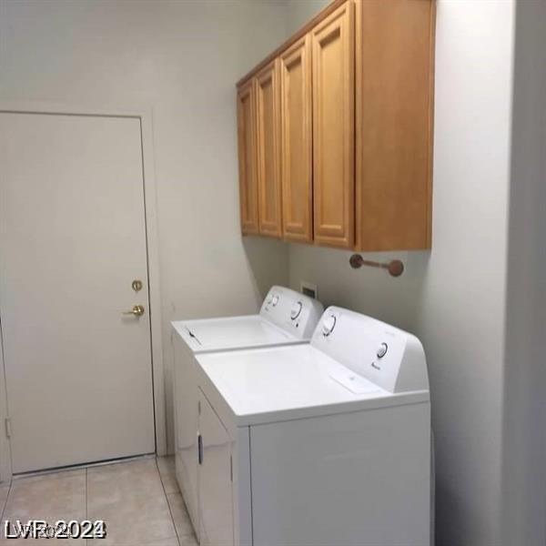 1652 Black Fox Canyon Rd, Henderson, NV 89052 - laundry room featuring washing machine and clothes dryer, cabinet space, and light tile patterned floors