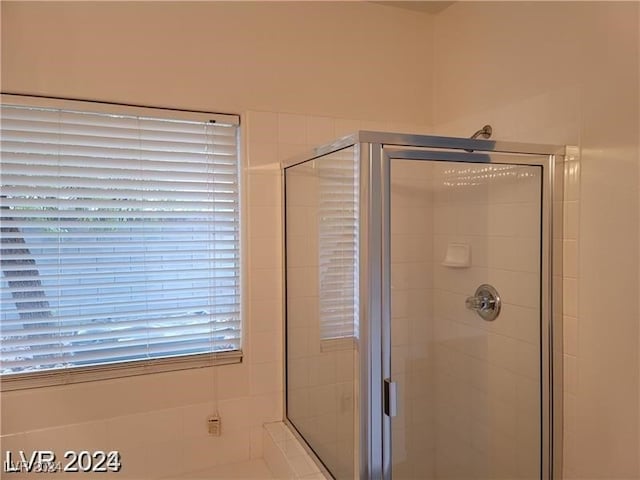 bathroom with a shower with door