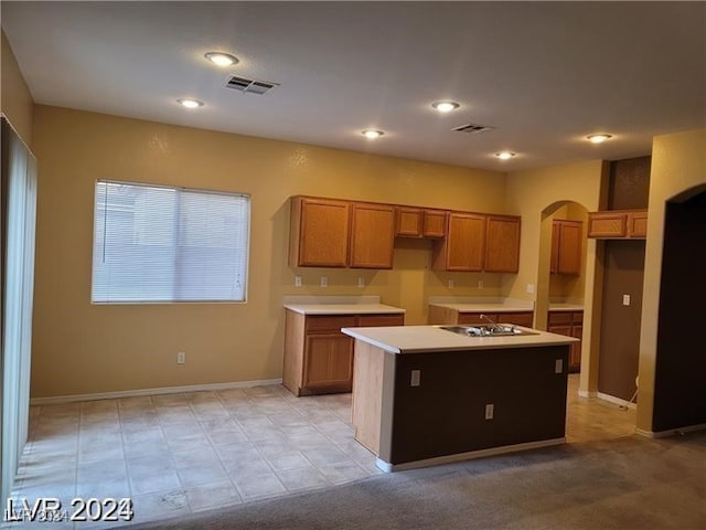 kitchen with a center island with sink and stovetop