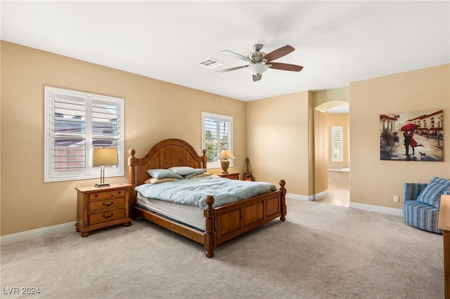 carpeted bedroom with ceiling fan and ensuite bathroom