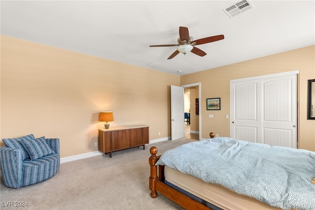 carpeted bedroom with ceiling fan and a closet