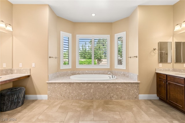 bathroom with vanity, tile patterned flooring, and tiled tub