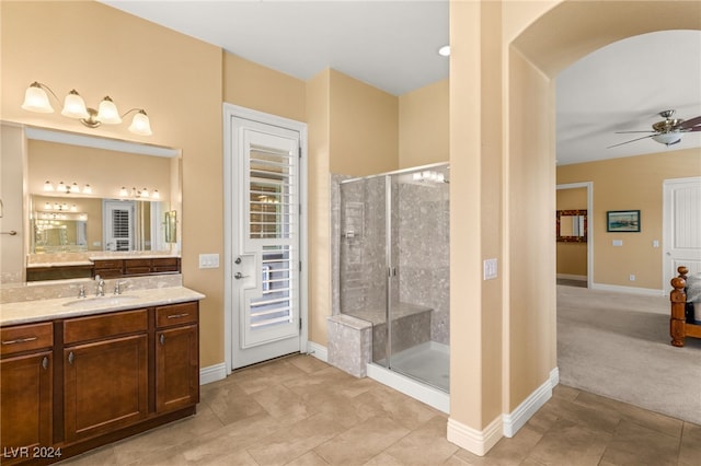 bathroom with ceiling fan, a shower with door, and vanity