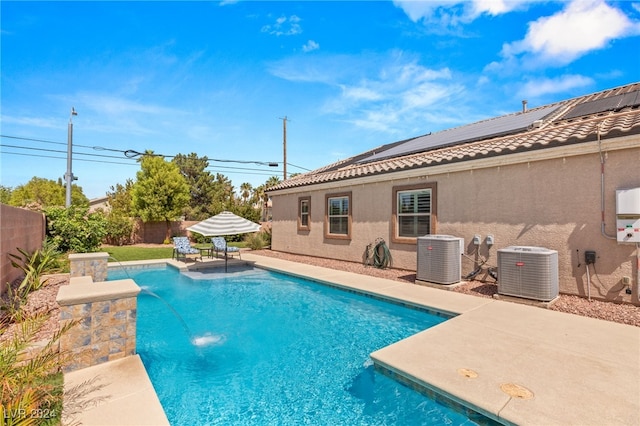 view of swimming pool featuring central AC unit, a patio, and pool water feature