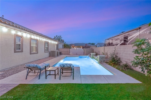 pool at dusk with central AC, a lawn, and pool water feature