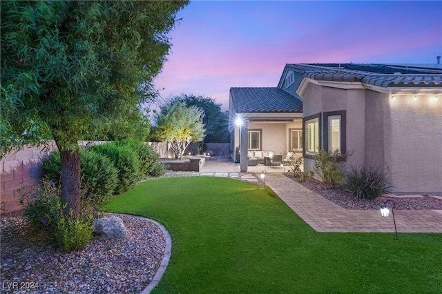 yard at dusk featuring an outdoor hangout area and a patio area