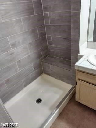 bathroom featuring vanity and a tile shower