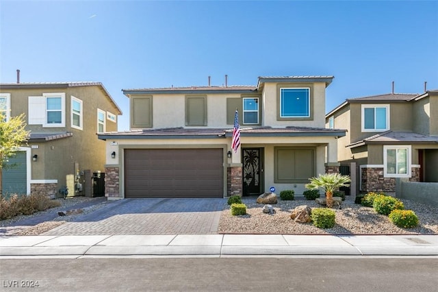 4323 Creekside Cavern Ave, North Las Vegas, NV 89084 - view of front of house with stucco siding, an attached garage, driveway, and stone siding