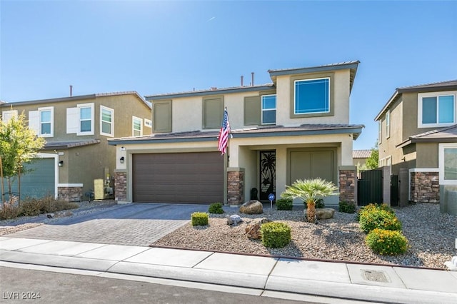 4323 Creekside Cavern Ave, North Las Vegas, NV 89084 - view of front facade with stucco siding, stone siding, a garage, and driveway