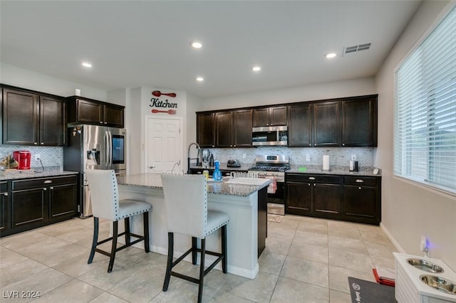 4323 Creekside Cavern Ave, North Las Vegas, NV 89084 - kitchen featuring appliances with stainless steel finishes, decorative backsplash, a breakfast bar, plenty of natural light, and recessed lighting