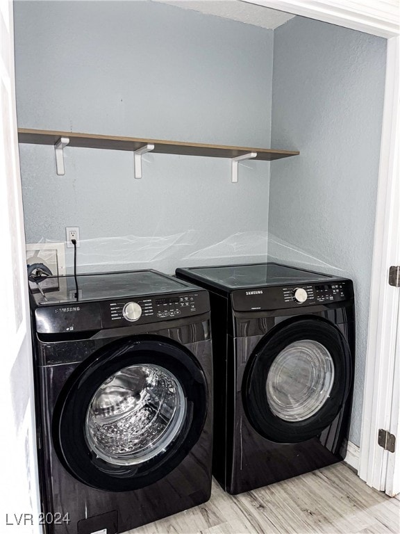 washroom featuring independent washer and dryer and light hardwood / wood-style flooring