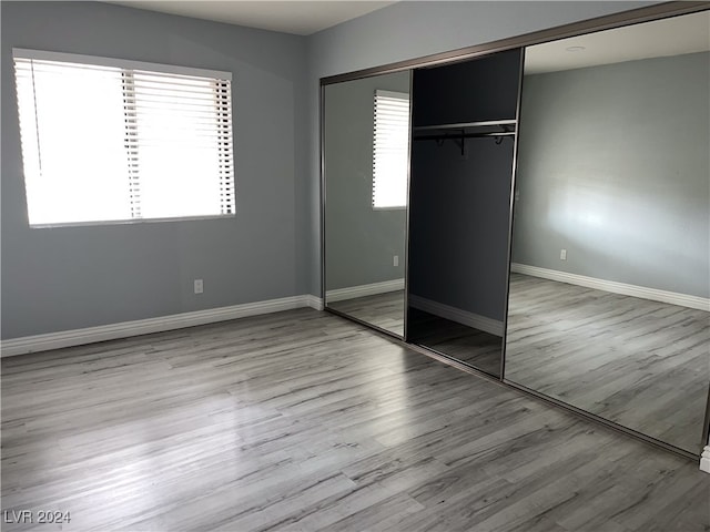 unfurnished bedroom with a closet and light hardwood / wood-style flooring