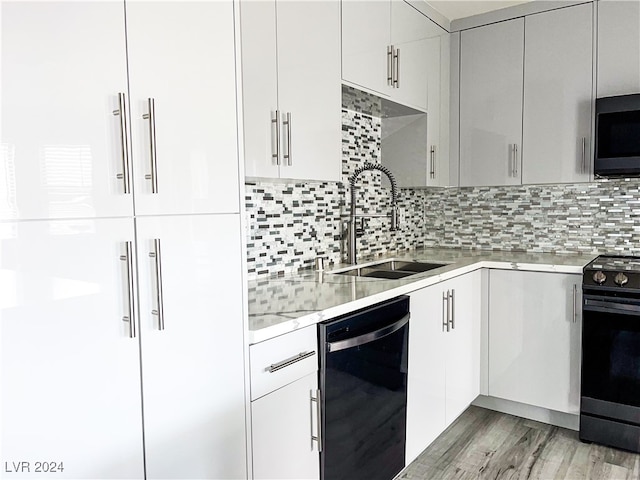 kitchen featuring white cabinets, sink, and black appliances