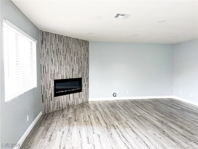 unfurnished living room with a fireplace and light hardwood / wood-style floors