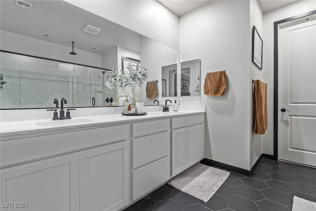 bathroom featuring a shower with door, vanity, and tile patterned flooring