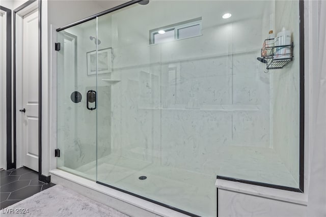 bathroom with a shower with shower door and tile patterned flooring