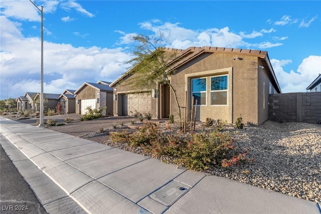 single story home with driveway, a residential view, fence, an attached garage, and stucco siding