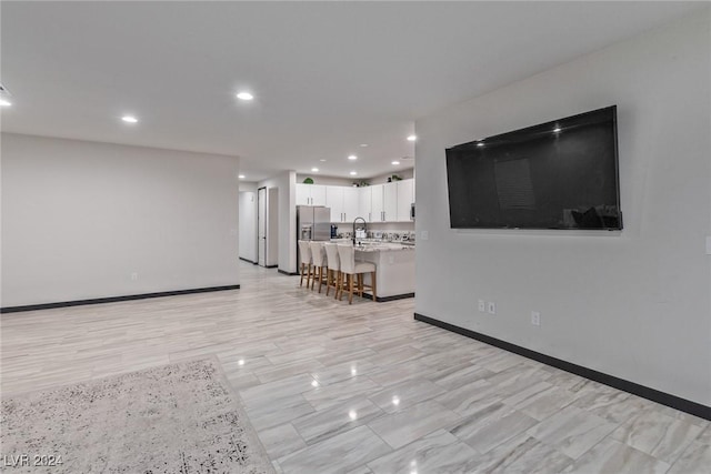 living area featuring recessed lighting and baseboards
