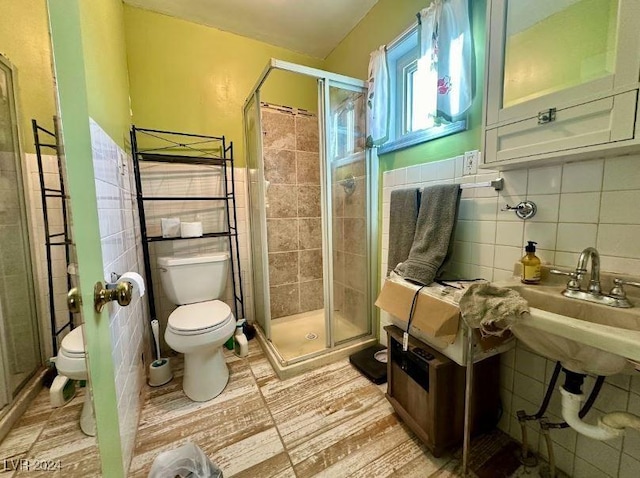 bathroom featuring toilet, tile walls, and walk in shower