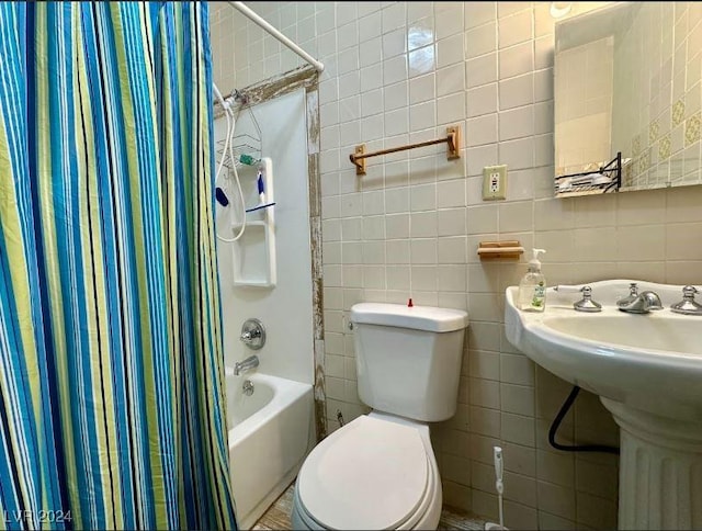 full bathroom with sink, toilet, shower / bathtub combination with curtain, and tile walls