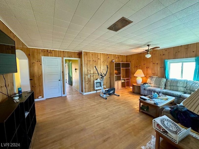 living room featuring wooden walls, ceiling fan, and hardwood / wood-style flooring