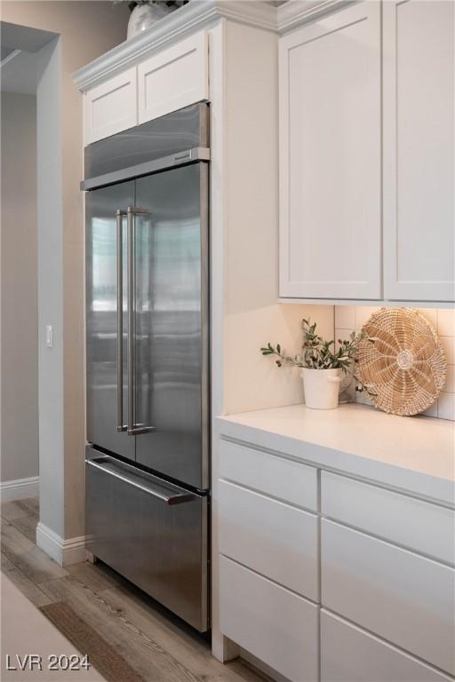 kitchen with white cabinetry, light hardwood / wood-style floors, and built in fridge