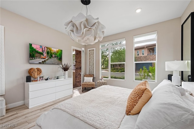 bedroom featuring a chandelier and light hardwood / wood-style flooring