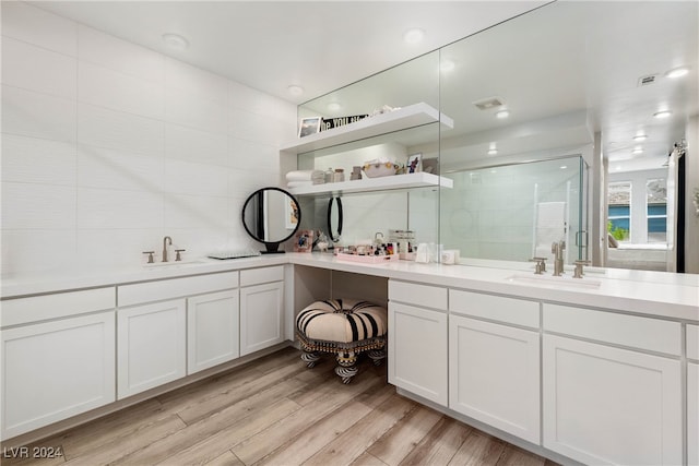 bathroom featuring vanity, an enclosed shower, hardwood / wood-style floors, and backsplash