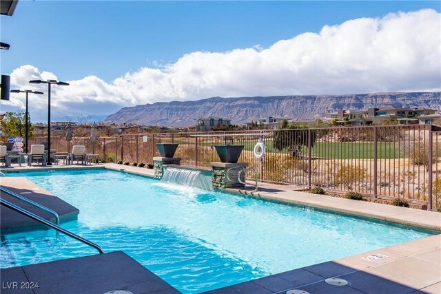 view of swimming pool featuring a patio area, a mountain view, and pool water feature