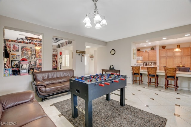 recreation room with a notable chandelier and light tile patterned floors