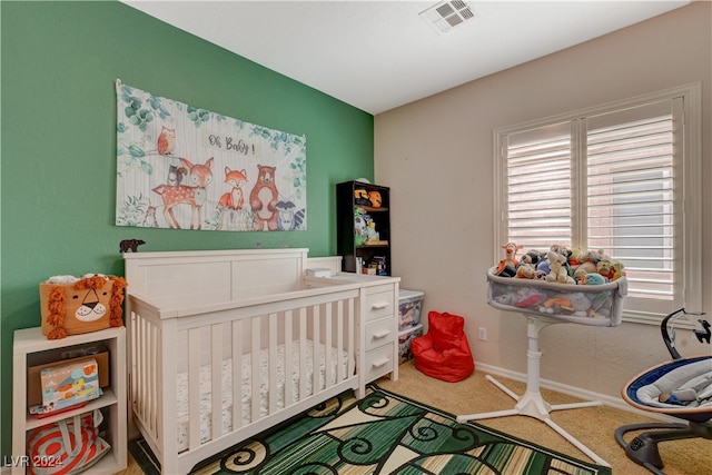 bedroom featuring carpet flooring and a crib