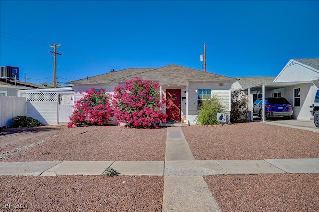 ranch-style house featuring central AC and a carport