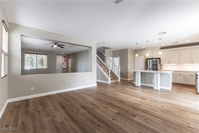 unfurnished living room featuring ceiling fan and light hardwood / wood-style flooring