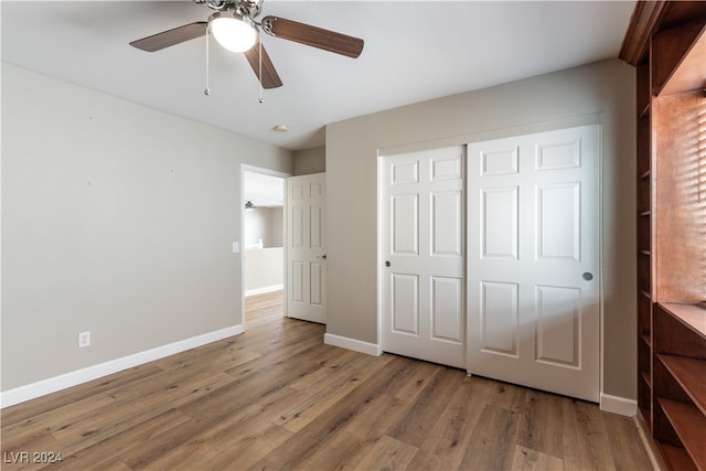 unfurnished bedroom with a closet, hardwood / wood-style floors, and ceiling fan