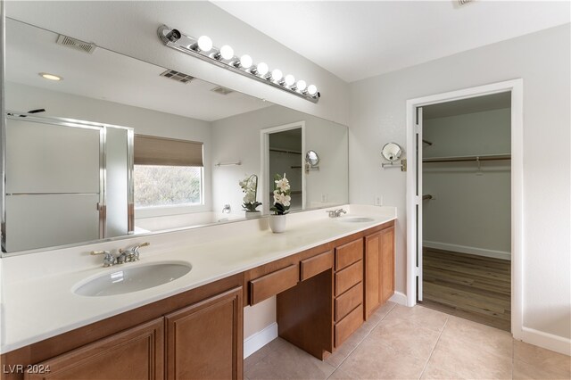 bathroom with tile patterned flooring, vanity, and a shower with door