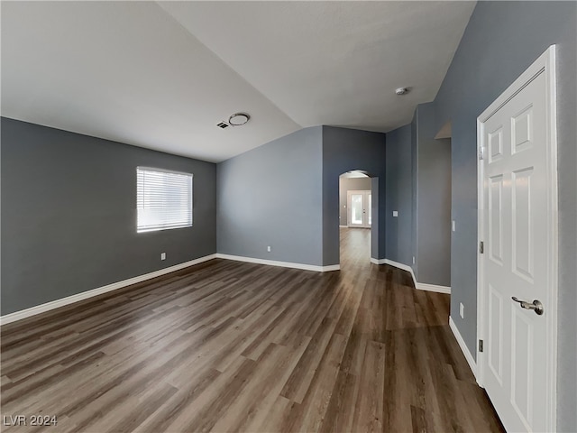 unfurnished room with vaulted ceiling and dark hardwood / wood-style floors