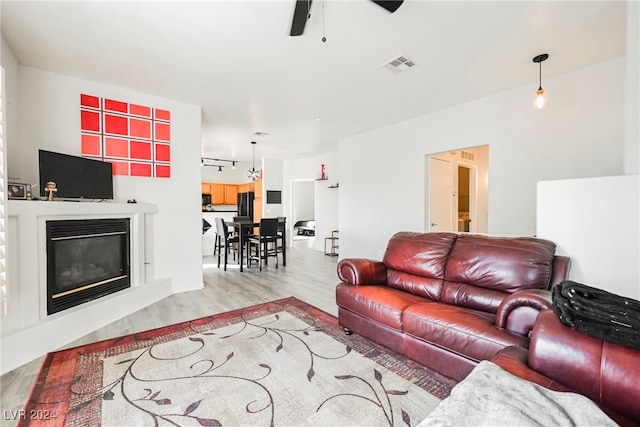 living room with ceiling fan and light hardwood / wood-style flooring