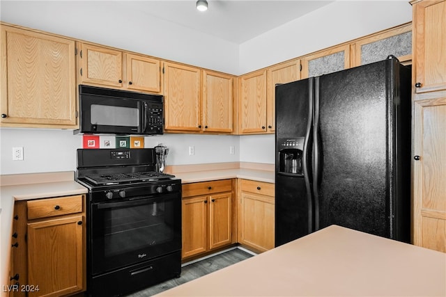 kitchen featuring black appliances, wood-type flooring, and light brown cabinets