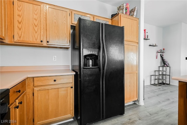 kitchen with black refrigerator with ice dispenser and light wood-type flooring