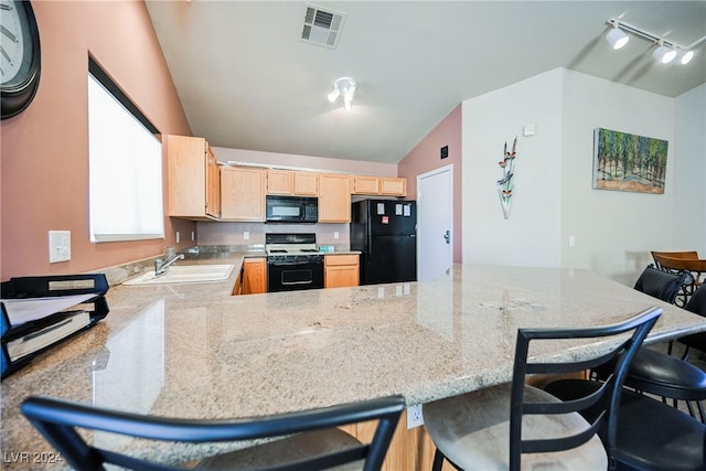 kitchen featuring black appliances, sink, kitchen peninsula, vaulted ceiling, and light brown cabinets