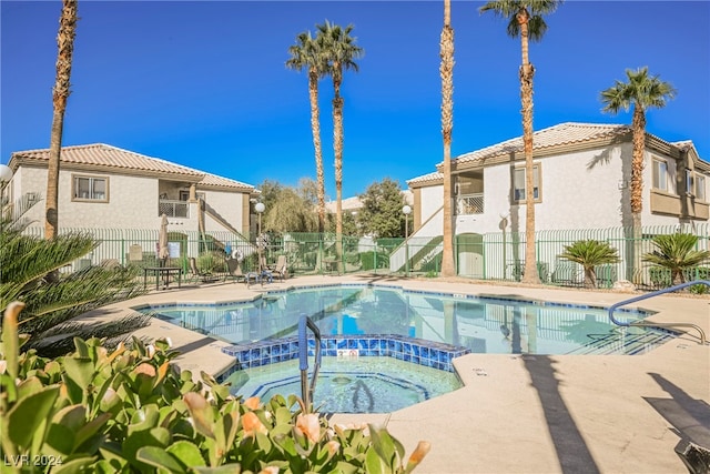 view of pool with a hot tub and a patio area